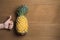 Ripe pineapple with various gestures of women hand on wooden background