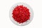 Ripe pomegranate fruit segment isolated on white background cutout. Close-up image of pomegranate seeds on white plate