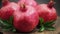 Ripe pomegranate fruits with leaves on wooden board. Slider shot