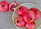 Ripe pomegranates in green vintage bowl on rustic rattan table