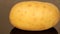 A ripe potato on a black pan closeup