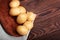 Ripe potato tubers on a bright brown background. A wooden basket full of fresh potatoes on a sack. A top view on vegetables.