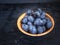 Ripe prunes in a cup close-up on a dark background