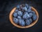 Ripe prunes in a cup close-up on a dark background