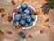 Ripe prunes in a cup close-up on a light wooden background.