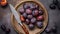 Ripe prunes in water drops and a fruit knife in a vintage copper plate