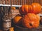 Ripe pumpkins and a bunch of ripe wheat lie on wooden barrels