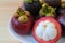 Ripe Purple Mangosteen Whole Fruits and Opened to Show tasty Pure White Meat