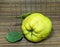 Ripe quince on the table close-up. Unusually shaped fruit. An ugly rotting quince. fruit with leaves. uneven shape. Healthy diet.