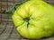 Ripe quince on the table close-up. Unusually shaped fruit. An ugly rotting quince. fruit with leaves. uneven shape. Healthy diet.