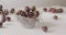 Ripe red cherries with droplets of water fall into a glass bowl on a white table. Soft focus. Slow panoramic motion