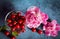 Ripe red cherry in a glass bowl with pink peonies