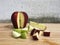 Ripe red and green apple whole, slice and slit pieces on wooden background