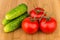 Ripe red tomatoes on branch and cucumber on board