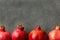 Ripe Red Vibrant Organic Pomegranates Arranged in Border on Black Stone Background Poster Greeting Card Template Banner Autumn