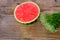 Ripe red watermelon, cut in half, home cooking concept, white wildflowers, wooden table, texture of natural background, delicious