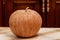 Ripe round pumpkin stands on table close-up