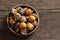 Ripe small persimmon fruit, black date or palm berries with branch on wooden background