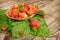 Ripe strawberries in a basket on a wooden table in raindrops.