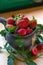 Ripe strawberries lie in a brown mug along with mint leaves on a wooden table among mint leaves