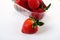 Ripe strawberries in a plastic package on a white background. Delicious fresh berries in a container for sale to