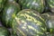 Ripe sugar sweet watermelons at a crates on stand at the marketplace. Selective focus