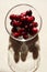 Ripe sweet cherries in glass bowl with water drops on beige table. Burgundy juicy berries. Summer vacation concept, warm days,