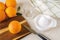 Ripe sweet oranges, plastic manual citrus juicer, fruit knife and empty glass on the kitchen table. Making freshly squeezed juice