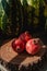 Ripe three pomegranates on a wooden round board, in the background watermelons. Harvesting concept. Sale of fruits.