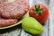 Ripe tomato bell peppers and raw homemade chopped beef burgers
