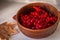 Ripe viburnum in clay bowl. Autumn beriies. Autumn harvest. Natural antioxidant. Natural flu remedy. Raw viburnum berries close up