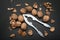 Ripe walnuts cracked with the help of an old nut cracker, a top view, a black background. Healthy food