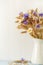 Ripe wheat in white vase on wooden background