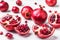 Ripe whole fruits and halves of red pomegranate on a white background. Juicy seasonal fruits. Source of vitamins. Diet, proper