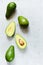 Ripe whole green avocado on a gray background. Flat lay. Food concept. Top view. Green avocadoes pattern