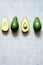 Ripe whole green avocado on a gray background. Flat lay. Food concept. Top view. Green avocadoes pattern