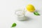 Ripe Yellow Lemon Green Citrus Leaves Sugar in Glass Jar. Ingredients for Face Scrub on White Concrete Stone Tabletop. Wellness