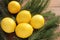 Ripe yellow lemons on wooden table decorated with Christmas tree branches. Fresh citrus fruits on wood background.