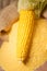 Ripe young sweet corn cob and cornmeal close up