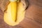 Ripe young sweet corn cob and cornmeal on wooden background