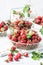 Ripen fresh strawberries in white braided metal container on white background, fresh homegrown berries served to eat