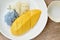 Ripen mango with white and purple sticky rice dressing coconut milk on plate