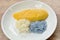 Ripen mango with white and purple sticky rice dressing coconut milk on plate
