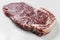 Ripened seasoned beef rump or striploin steak on white background