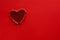 Ripped paper hole heart shaped on red paper background. Valentine`s day celebration concept