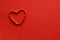 Ripped paper hole heart shaped on red paper background. Valentine`s day celebration concept