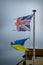 Ripped and tattered Union jack flag and Ukrainian flag fly together. Shredded and worn