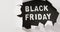 Ripped white paper over black friday text in white on black background