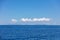 Rippled Aegean Sea, cloud on blue sky over Serifos island rocky land. Seascape, Cyclades Greece