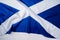 Rippled flag of Scotland lying on white surface